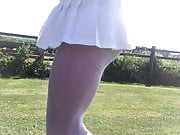 Windy upskirt in white pantyhose and pleated mini skirt
